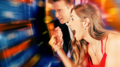 Gambling couple in Casino or amusement arcade on slot machine winning