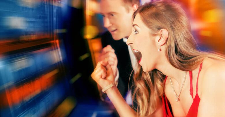 Gambling couple in Casino or amusement arcade on slot machine winning