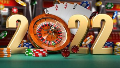 2022 Happy New Year in casino. Numbers 2022 from roulette, casiino chips with dice and card on green table. 3d illustration