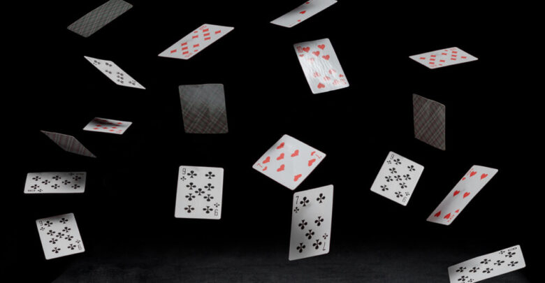 playing cards fall on a black table